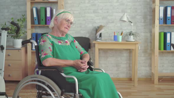 Lonely Sad Old Woman with Glasses Sitting in a Wheelchair