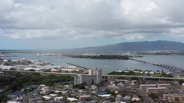 Panning aerial dolly shot of Pearl Harbor with the USS Arizona Memorial in the background on the isl