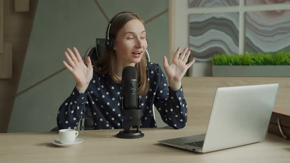 Woman with Microphone and Laptop Computer Talking and Recording Podcast at Studio