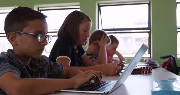 Boy using laptop in the class