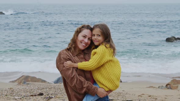 Portrait of Young Mom Holding Her Girl In Her Arms