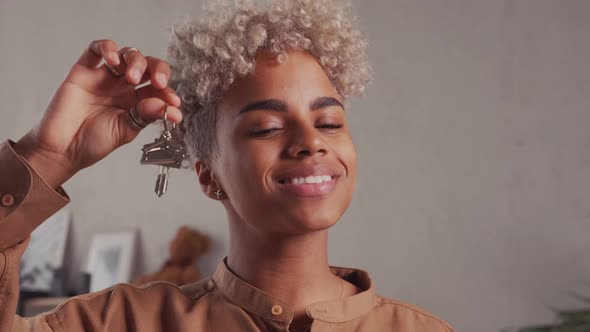 Close Up Focus on Keys in Hands of Blurred Smiling Young African American Female