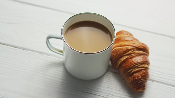 Cup of Coffee and Baked Croissant