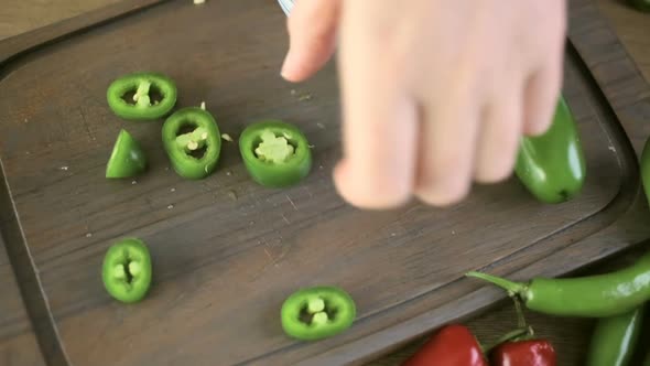 Slicing Jalapeno Pepper on a small cutting board.