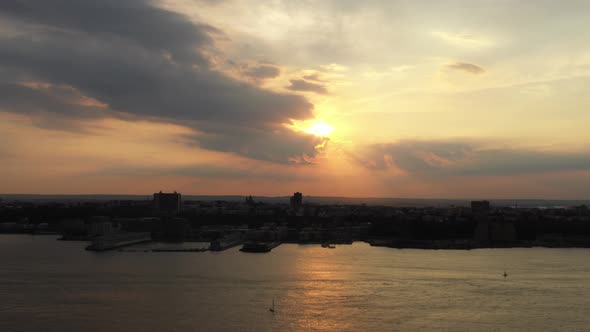 aerial drone shot, pan left showing a golden sunset from Hudson Yards, looking towards New Jersey