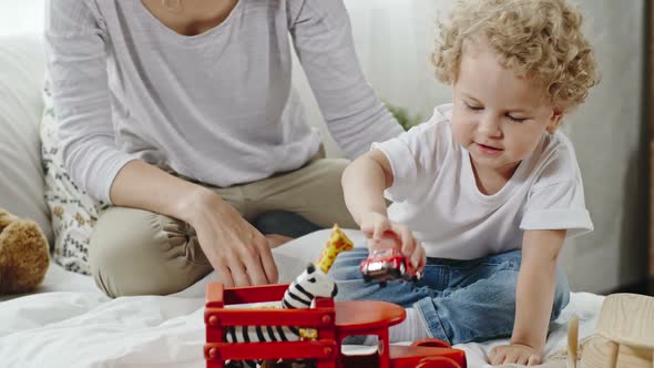 Angelic Little Boy Playing with Wooden Toy Cars alt