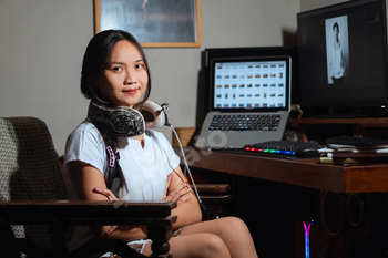 Woman in home office with laptop and desktop computer