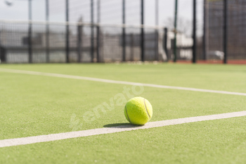 Tennis ball on a tennis court next to the side line