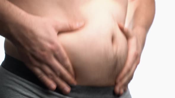 The Man Shakes His Plump Belly with Both Hands