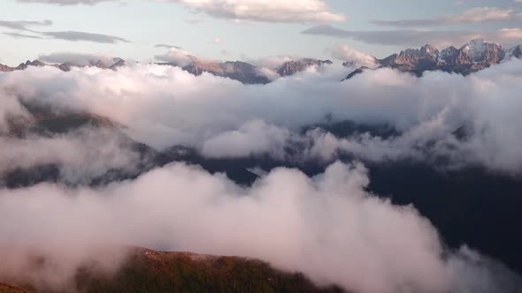 Landscape of Snowy Rocky Mountains Over the Clouds in the Valley