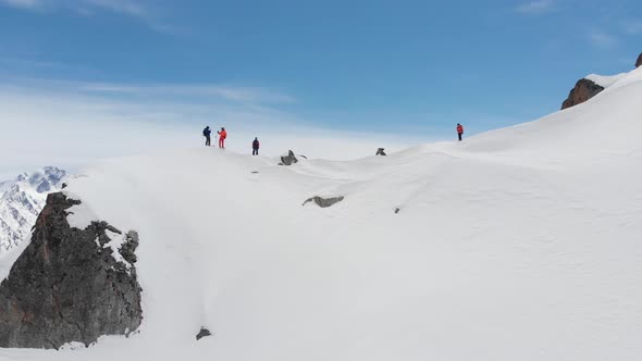 Aerial View of a Group of Skiers and Snowboarders on Top of a Snow-capped Mountain