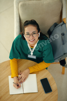 Portrait of Smiling Nurse Writing in Notebook