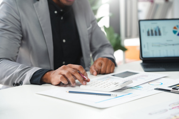 Businessman calculating profit using calculator in office