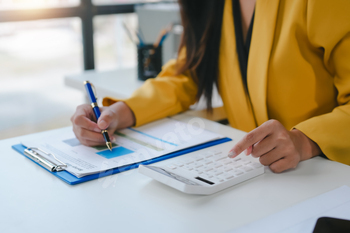 Businesswoman calculating financial data using calculator in office