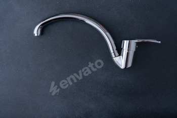 Chrome-plated mixer tap for water in the bathroom and kitchen. Plumbing.