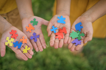 Multicolor paper puzzles in the hands of children.