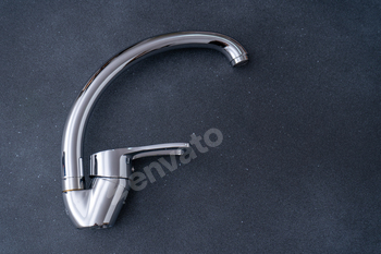 Chrome-plated mixer tap for water in the bathroom and kitchen. Plumbing.