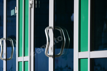 Chrome door handle and glass of modern aluminium office facade