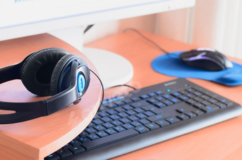 Big black headphones lie on the wooden desktop of the sound designer