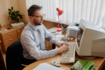 Working in Office with Desktop Computer and Glasses