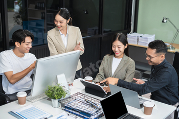 Business team working on a project in the office or reviewing and discussing a business project.