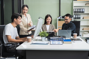 Business team working on a project in the office or reviewing and discussing a business project.