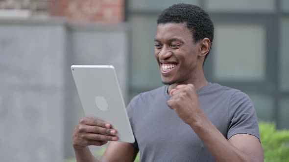 Portrait of Excited African Male Design Celebrating Success on Tablet 