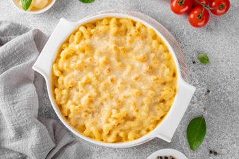 Mac and cheese in a white baking dish. American cuisine, comfort food. Copy space.