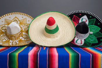 Mexican hats with the colors of the Mexican flag on a colorful serape.