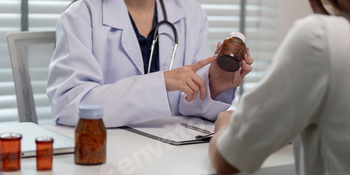 Doctor Consulting Patient and Prescribing Medication in a Modern Medical Office Setting