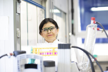 Confident scientist with a bright smile in a lab environment.