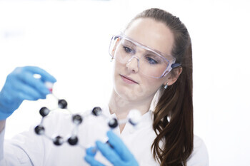 Focused scientist examining a molecular model in a lab