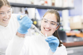 Two scientists sharing a moment of discovery in the lab.