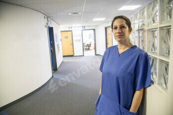 Medical professional standing in hospital corridor, medical practice UK