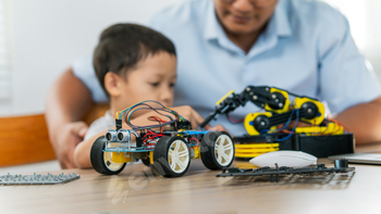 A boy are learning to build robot toys with their dad in the living room. Robot model