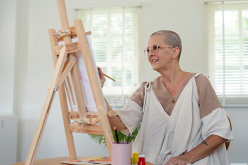 Senior woman painting on canvas at home, Elderly woman painting on a canvas, Happy retirement