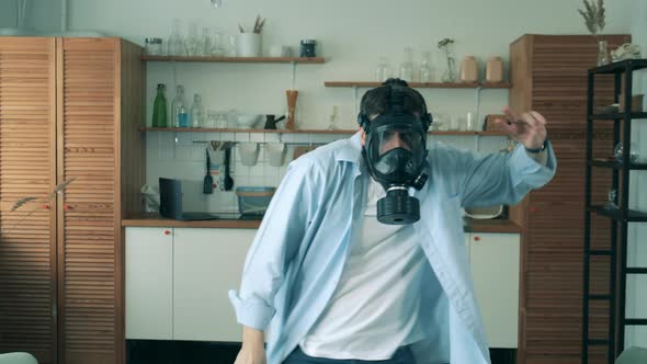 A Man Wearing a Hazmat Mask Is Dancing at Home During Pandemic of Coronavirus, Covid-19.