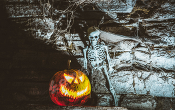 scary Halloween background with Jack'o'lanterns and skeleton