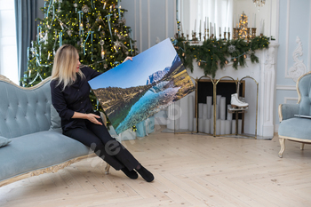 woman holding a photo canvas as a Christmas present