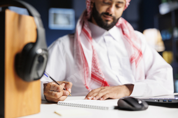 Arab student writing on his notebook