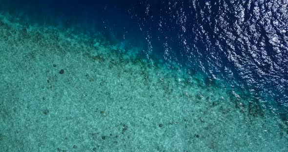 Wide flying clean view of a paradise sunny white sand beach and aqua turquoise water background in c