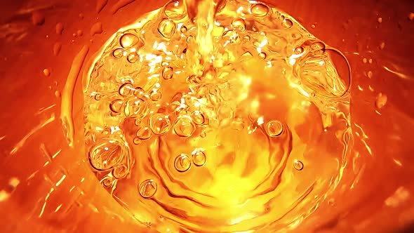 Close up top view of glass being filled with water. Golden effect