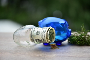 Saving money in glass jar and in piggy bank. The concept of saving money