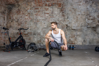 A man engaged in fitness and sports trains with ropes in the cross fit gym.Fitness,healthy lifestyle