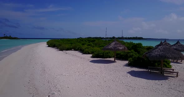 Wide angle drone tourism shot of a white sand paradise beach and turquoise sea background in 4K