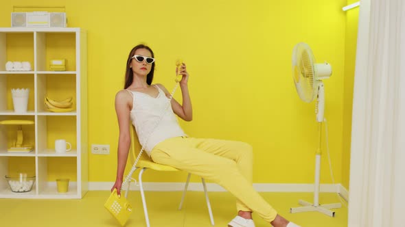 Young Woman Is Posing With Yellow Retro Telephone