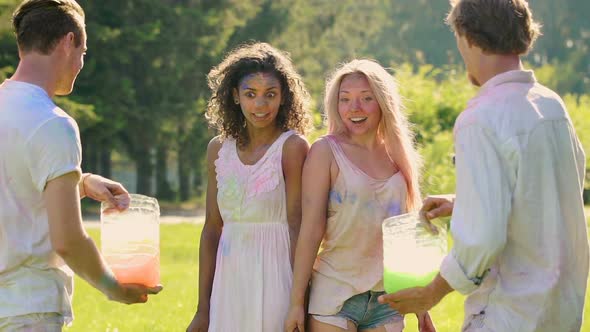 Two Guys Splashing Water at Their Girlfriends Outdoors at Color Fest Slow-motion