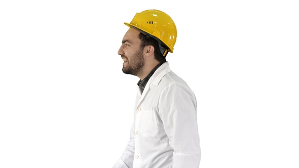 Smiling construction engineer catching a cap and putting