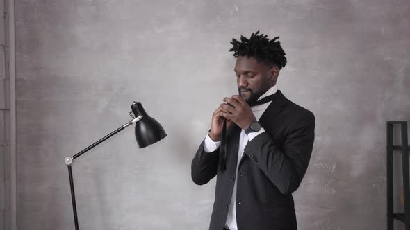 African American Businessman in Suit Putting on Tie