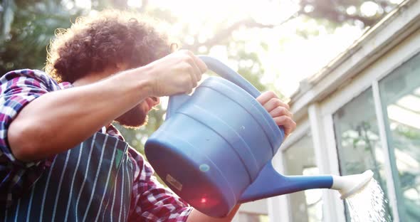 Gardener watering plants with watering can